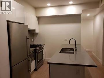 Vancouver apartment for rent - A kitchen with a stainless steel refrigerator and a sink.