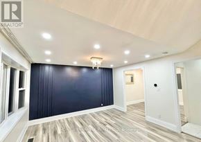 Kitchener apartment for rent - A spacious room with dark blue walls and light wood flooring.