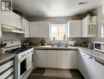 Georgina (Keswick North) apartment for rent - A white kitchen with a stove, sink, and cabinets.