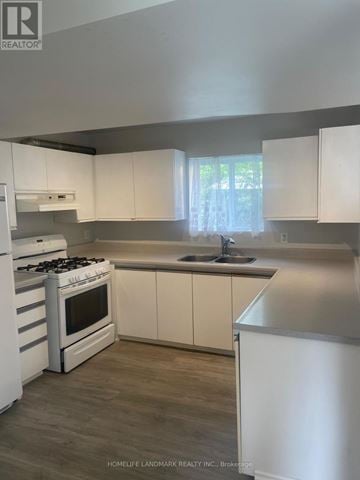 Georgina (Keswick North) apartment for rent - A kitchen with white cabinets and a stove top oven.