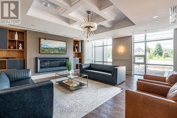 Hamilton (Waterdown) condo for rent - A living room with a black couch, a coffee table, and a painting on the wall.