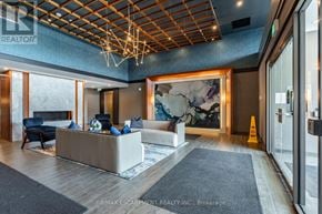 Hamilton (Waterdown) condo for rent - A modern office lobby with a reception desk and a large abstract painting on the wall.