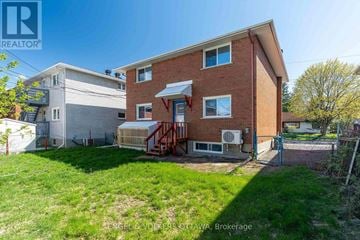 Ottawa duplex for rent - A house with a red brick exterior and a white garage door is for sale.