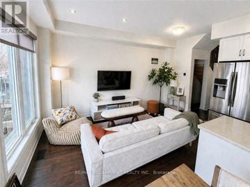 Hamilton (Villages Of Glancaster) townhouse for rent - A modern living room with a white couch and a flat screen TV mounted on the wall.