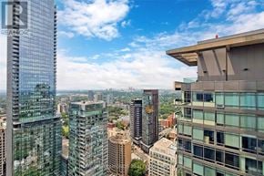 Toronto (Annex) condo for rent - A cityscape with tall buildings and a clear sky.