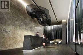 Toronto (Annex) condo for rent - A reception area with a woman standing behind a desk and a man standing in front of her.