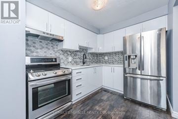 Brampton (Bramalea West Industrial) townhouse for rent - A kitchen with white cabinets and a stainless steel refrigerator.