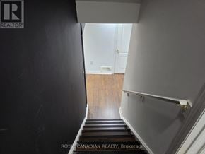 Milton (Sc Scott) apartment for rent - A stairway with a black railing and wooden steps.