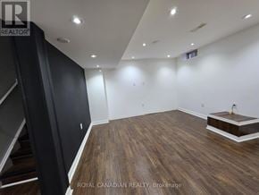 Milton (Sc Scott) apartment for rent - A spacious room with wooden flooring and a staircase on the left side.