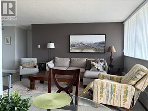 Mississauga (Meadowvale) condo for rent - A living room with a couch, chair, and lamp.