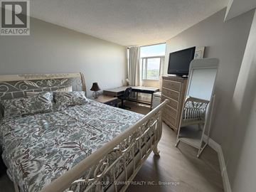Mississauga (Meadowvale) condo for rent - A bedroom with a large bed and a TV on a dresser.