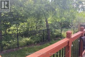 Burlington (Alton) apartment for rent - A wooden deck with a black fence and green trees in the background.