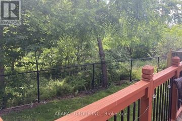 Burlington (Alton) apartment for rent - A wooden deck with a black fence and green trees in the background.