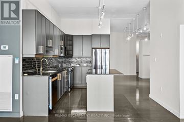 Hamilton (Durand) condo for rent - A kitchen with a black counter top and stainless steel appliances.