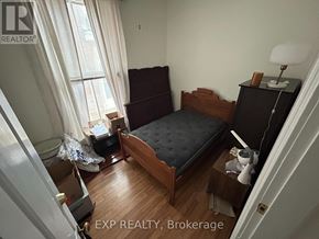 London East (East F) fourplex for rent - A bedroom with a bed, nightstand, and window.