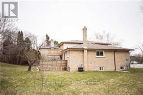 Toronto (Don Valley Village) apartment for rent - A house with a brown roof and a chimney is surrounded by a grassy lawn.