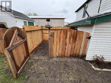 Prince Edward County (Picton Ward) duplex for rent - A wooden fence with a gate is in front of a house.