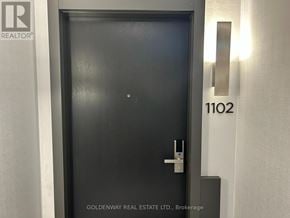 Markham (Unionville) condo for rent - A black door with a silver handle and a number 1102 on the wall.
