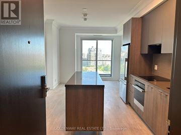 Markham (Unionville) condo for rent - A kitchen with wooden cabinets and a black countertop.
