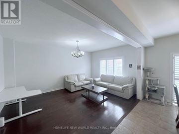 Markham (Wismer) townhouse for rent - A living room with white furniture and a chandelier.