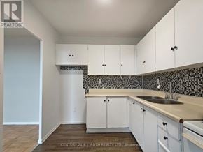 Barrie (Allandale) apartment for rent - A kitchen with white cabinets and a black and white checkered backsplash.
