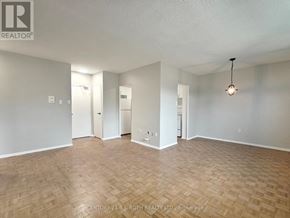 Barrie (Allandale) apartment for rent - A spacious room with wooden flooring and white walls, ready for occupancy.