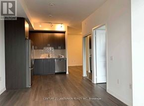 Toronto (Henry Farm) condo for rent - A kitchen with dark wood cabinets and a white fridge.