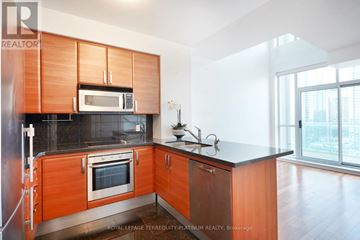 Toronto (Willowdale East) condo for rent - A kitchen with wooden cabinets and a black countertop.