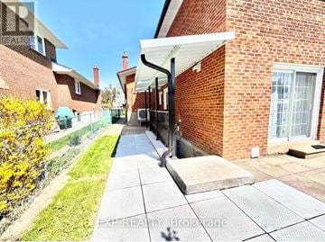 Toronto (L'amoreaux) apartment for rent - A brick house with a white door and a small garden.