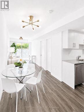 Toronto (New Toronto) townhouse for rent - A modern kitchen with a glass table and white chairs.