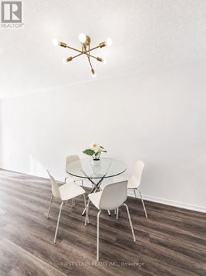 Toronto (New Toronto) townhouse for rent - A bedroom with a large bed and a nightstand with a lamp.