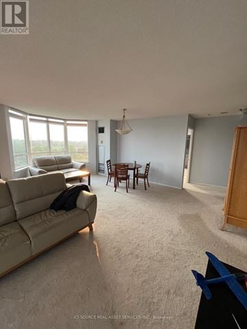 Toronto (Milliken) condo for rent - A living room with a couch, a table, and a dining table with chairs.