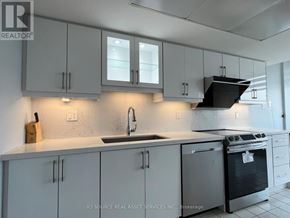 Toronto (Milliken) condo for rent - A kitchen with white cabinets and a black stove top oven.