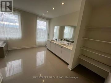 Toronto (Downsview-Roding-Cfb) townhouse for rent - A spacious kitchen with white cabinets and a large island.