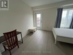 Toronto (Downsview-Roding-Cfb) townhouse for rent - A bedroom with a bed, chair, and window.