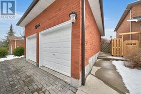 Newmarket (Armitage) apartment for rent - A red brick house with a white garage door and a black lamp on the wall.