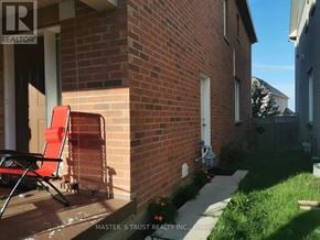 East Gwillimbury apartment for rent - A red chair is on the porch of a brick house.