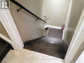 East Gwillimbury apartment for rent - A staircase with a wooden handrail and a tiled floor.