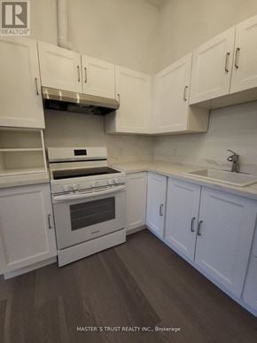 Uxbridge condo for rent - A white kitchen with a stove and cabinets.