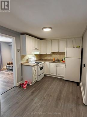 Orillia apartment for rent - A kitchen with white appliances and cabinets.
