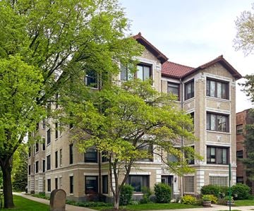 Oak Park apartment for rent - A large building with a red roof and a tree in front of it.
