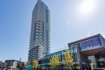 Coquitlam apartment for rent - A tall building with a blue and white facade stands next to a smaller building with a glass facade.