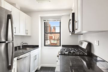 New York apartment for rent - a kitchen with black counter tops and a window