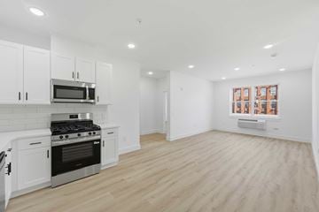 Paterson apartment for rent - A kitchen with white cabinets and a stove top oven.