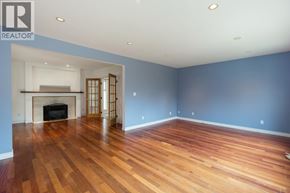 Burnaby apartment for rent - A large empty room with wooden floors and a fireplace.
