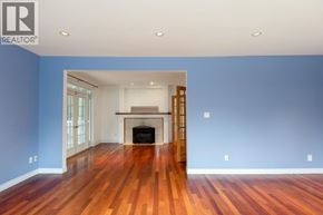 Burnaby apartment for rent - A spacious room with a fireplace and wooden floors.