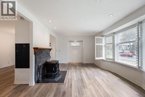 Burnaby apartment for rent - A spacious living room with wood flooring and a fireplace.