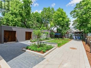 Toronto (Kensington-Chinatown) townhouse for rent - A modern outdoor patio area with a brick patterned walkway and a small garden.