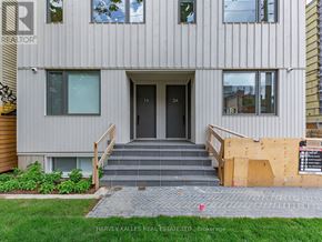 Toronto (Kensington-Chinatown) townhouse for rent - A modern building with a grey facade and a black door.