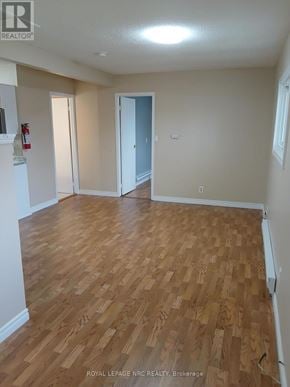 Niagara Falls (Downtown) fourplex for rent - A room with wooden flooring and a doorway leading to another room.
